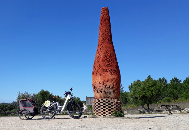 Ebike and trailer beside terracotta chimney at Quinta do Pisao in Cascais