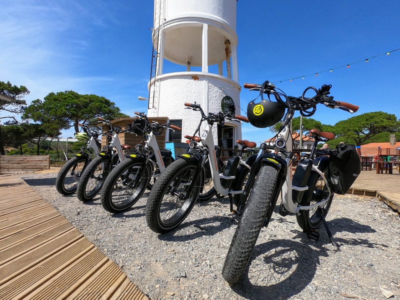 Fat tire ebikes parked by a water tower near the Atlantic ocean in Sintra